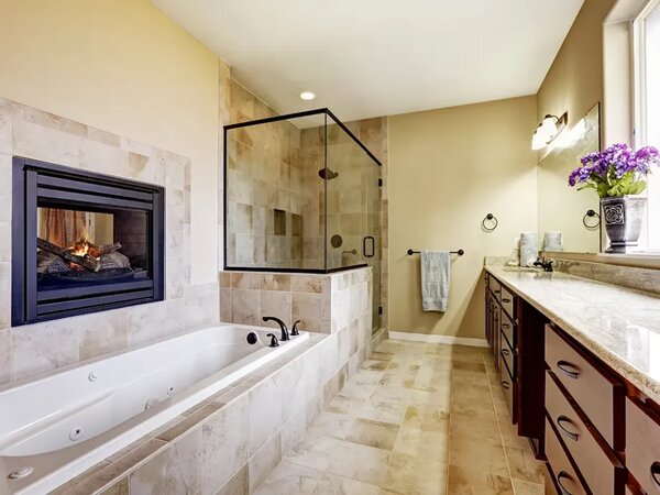 Blog picture with a modern master bathroom that has a fireplace and window and glass shower