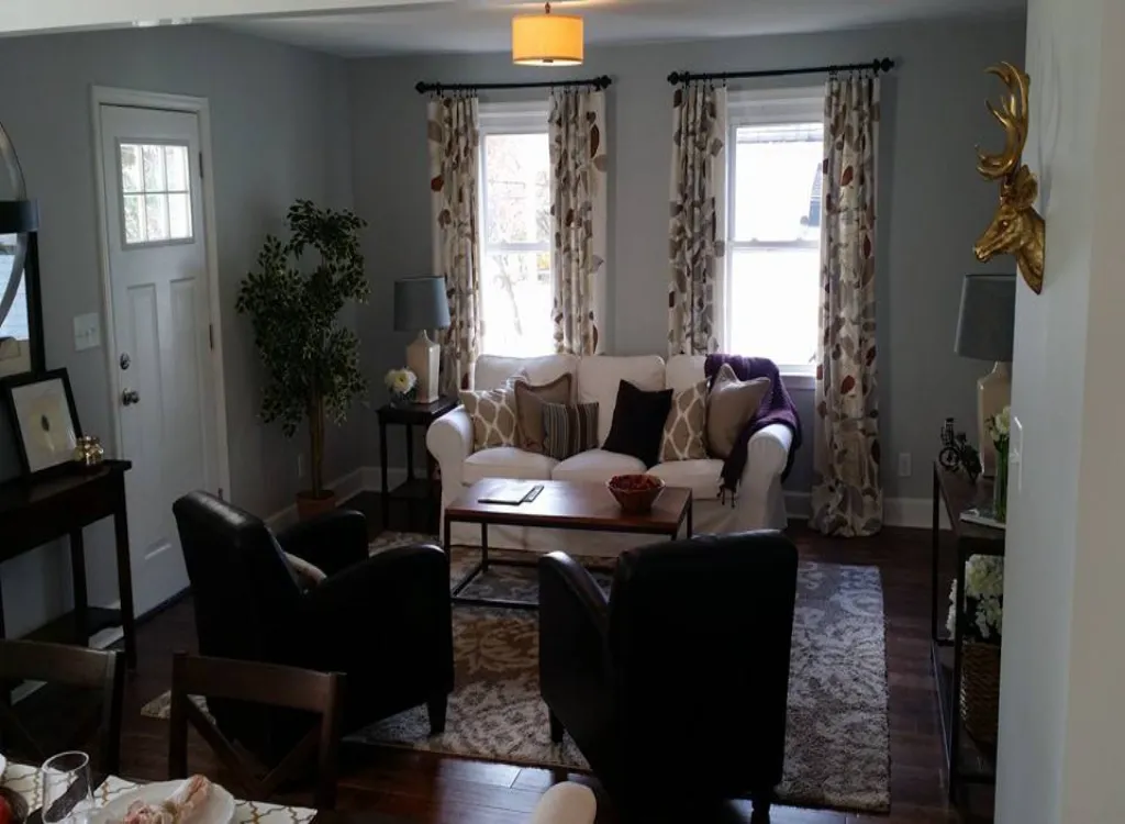 A living space with a white couch and two easy chairs.