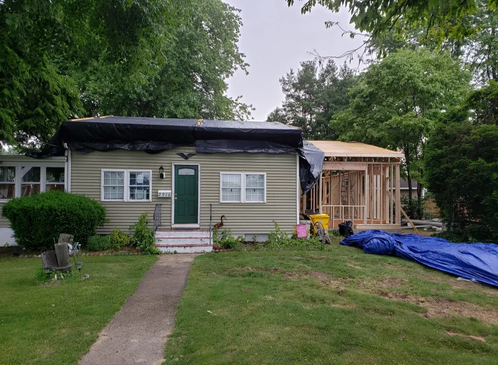 An attached home addition under construction with wood framing visible.