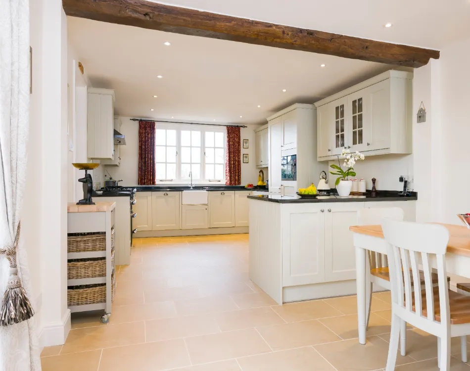 A white kitchen with a beautiful light brown porcelain tile floor.