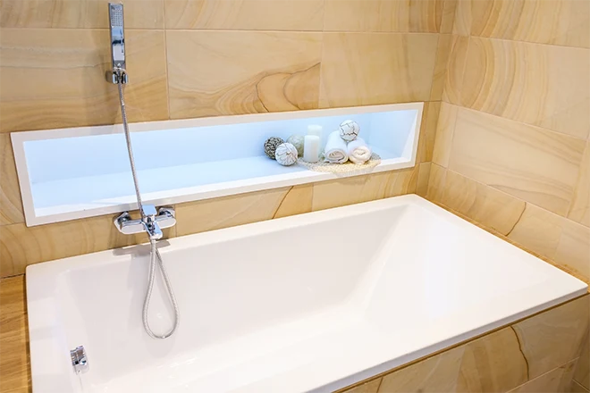 Bathtub with niche and beautiful beige stone
