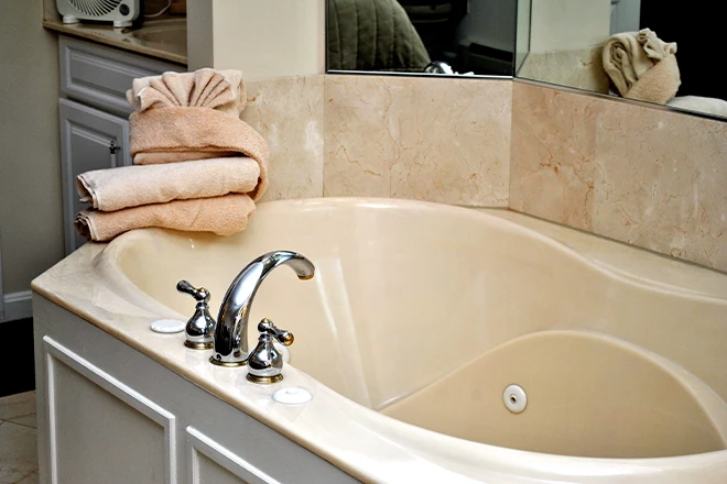 Built in bathtub with jets and natural stone tile surround