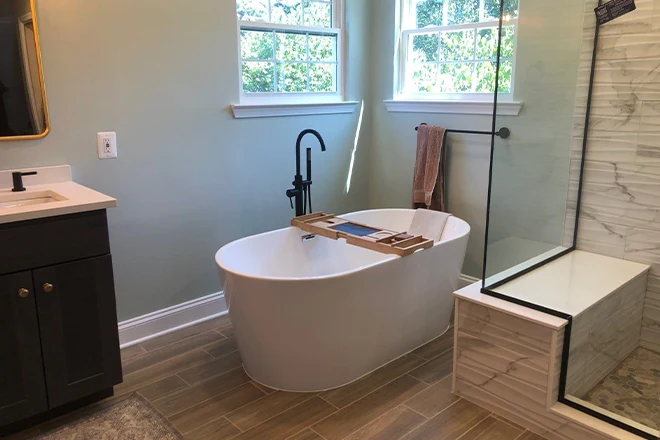 Freestanding soaking bathtub beneath windows