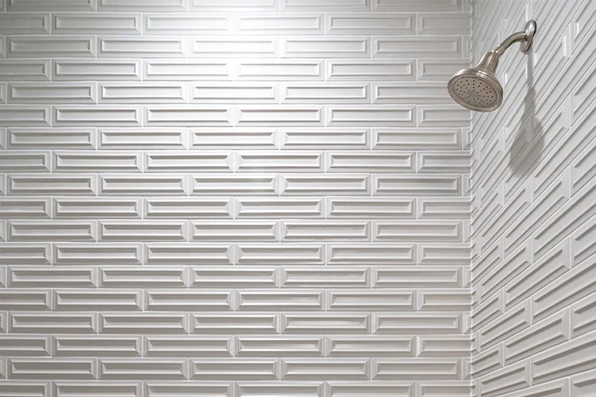 Modern shower and bathtub with chrome hardware and gray subway tile pattern