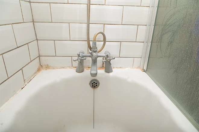 Worn down bathtub with stains